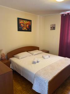 ein Schlafzimmer mit einem Bett mit weißer Bettwäsche und einem roten Vorhang in der Unterkunft Lovely apartment with fabulous view in Koper