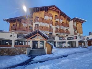 ein großes Gebäude mit Schnee davor in der Unterkunft Appartement skis aux pieds avec balcon et parking - FR-1-344-880 in Les Bruyères