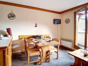 a dining room with a wooden table and chairs at Appartement 2 pièces, Départ ski aux pieds, Balcon sud - FR-1-344-904 in Les Bruyères