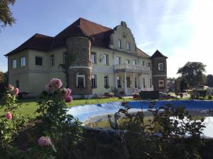 a large house with a swimming pool in front of it at Gutshaus Darsikow in Darsikow