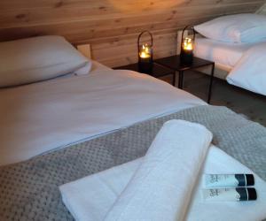 a hotel room with two beds with towels on them at Sauna balia - Nowa Osada Domki przy plaży - całoroczne domki na Mazurach in Ryn