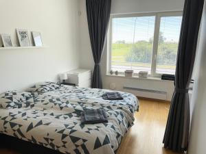 a bedroom with two beds and a large window at Papli Seaview Apartment in Pärnu