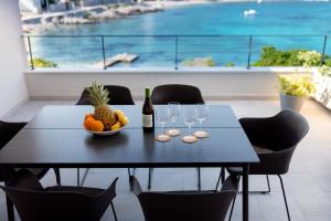 una mesa con un bol de frutas y copas de vino en The Plaza Apartment, en Prizba