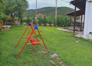 un columpio rojo y azul en un patio en Stavrini's House, en Elevtheraí