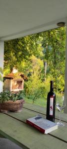 a bottle of wine and a book and a glass at MontenegrinaBiH, Petrovici, Istocno Sarajevo in Sarajevo
