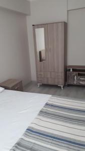 a bedroom with a bed and a dresser and a mirror at Geyikli suit apart3 in Geyikli