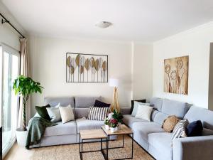 uma sala de estar com um sofá e uma mesa em Precioso Bajo gran terraza y piscinas Altaona Golf em Múrcia