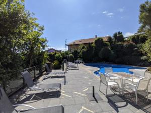 un grupo de sillas y mesas junto a una piscina en Apartamentos Mazuga Rural, en Póo