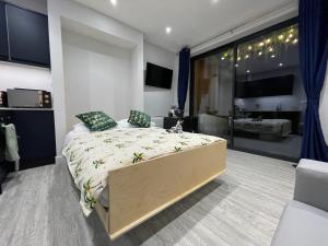 a bedroom with a large bed and a large window at Coastline Retreats - Brand New Jungle Themed Garden Apartment - Outdoor Bath - Next to Seafront - Childrens Toys - Superfast Wifi - Netflix - Disney in Southbourne