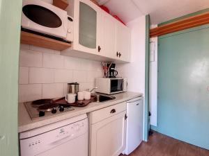 a small kitchen with a sink and a microwave at Studio Les Menuires, 1 pièce, 3 personnes - FR-1-344-931 in Les Menuires