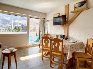 a dining room with a table and chairs and a window at Studio rénové confortable, accès piste, balcon sud - FR-1-344-953 in Les Menuires +3 photos