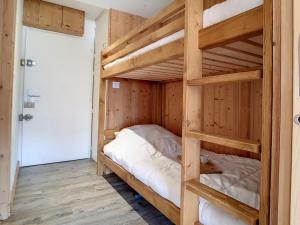 two bunk beds in a room with wooden walls at Studio Les Menuires, 1 pièce, 4 personnes - FR-1-344-953 in Les Menuires