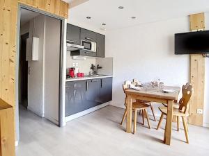 a kitchen and dining room with a table and chairs at Studio rénové proche pistes avec balcon, 3 couchages - FR-1-344-948 in Les Menuires +6 photos