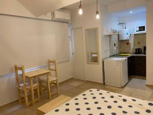 una pequeña cocina con mesa, sillas y nevera. en Cozy Apartment en Buenos Aires