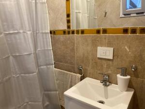 y baño con lavabo blanco y espejo. en Cozy Apartment en Buenos Aires
