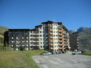 a large building with cars parked in a parking lot at Studio rénové proche pistes avec balcon, 3 couchages - FR-1-344-948 in Les Menuires