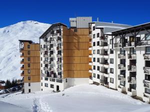 um edifício na neve em frente a uma montanha em Appartement Les Menuires, 2 pièces, 4 personnes - FR-1-344-969 em Les Menuires