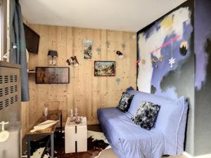 uma sala de estar com um sofá azul num quarto em Studio Les Menuires, 1 pièce, 4 personnes - FR-1-344-985 em Les Menuires