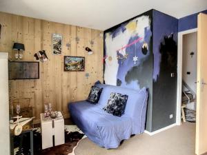 uma sala de estar com um sofá azul no canto em Studio Les Menuires, 1 pièce, 4 personnes - FR-1-344-985 em Les Menuires