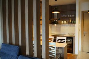 ein Wohnzimmer mit einer blauen Couch und einer Küche in der Unterkunft Apartmani Joksic Zlatibor in Zlatibor + 9 Fotos