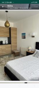a bedroom with a large bed and a kitchen at Suites 5* Lahcene in Alicante