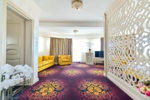 Hotel Belona في إيفوري نورد: غرفة معيشة مع أريكة صفراء وسجادة حمراء