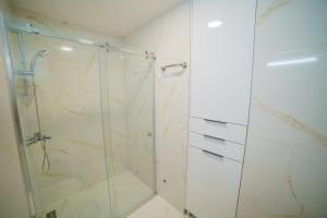 ein Badezimmer mit Dusche mit Glastür in der Unterkunft Apartmani Joksic Zlatibor in Zlatibor
