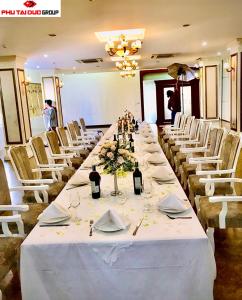 a long table with white tables and white chairs at White Hotel in Hà Tĩnh