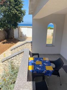 einen Tisch und Stühle auf einer Terrasse mit Meerblick in der Unterkunft Apartmani Sirius in Silba