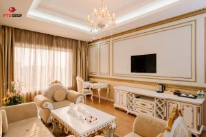 a living room with a couch and a tv at White Hotel in Hà Tĩnh