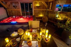 Zimmer mit einer Badewanne und einem Tisch mit Essen und Kerzen in der Unterkunft Le Bassin du Tertre in Fronsac