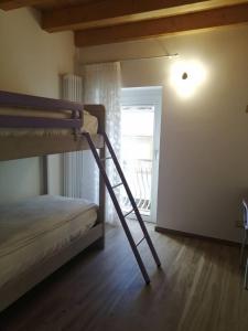 Etagenbett in einem Zimmer mit einer Leiter in der Unterkunft Cadore Luminoso appartamento in Calalzo