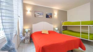 a bedroom with a red bed and bunk beds at Patrizia in Bibione