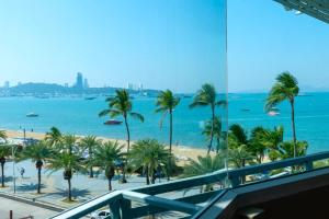 a view of a beach with palm trees and the ocean at The Beach Front Resort, Pattaya in Pattaya