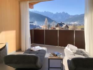 una sala de estar con 2 sofás y una ventana grande en Bergzeit Gosau en Gosau