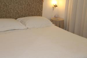 - une chambre avec un lit blanc et une table de chevet dans l'établissement Dimora "Bianca Ostuni", à Ostuni