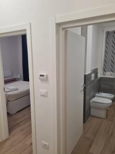 eine offene Tür zu einem Bad mit einem WC und einem Bett in der Unterkunft LU.NA in Bologna