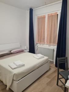 een slaapkamer met een bed, een stoel en een raam bij LU.NA in Bologna
