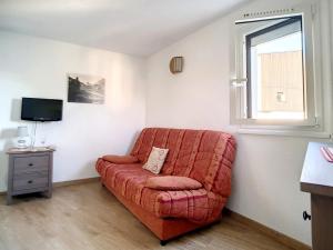 - un canapé rouge dans une pièce avec fenêtre dans l'établissement Appartement Les Menuires, 2 pièces, 5 personnes - FR-1-344-1031, aux Menuires