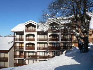 聖馬丁德貝爾維爾的住宿－Appartement Saint-Martin-de-Belleville, 2 pièces, 4 personnes - FR-1-344-1020，一座有雪覆盖的建筑,前面有一棵树