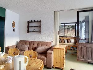 ein Wohnzimmer mit einem Sofa und einem Tisch in der Unterkunft Appartement Les Menuires, 3 pièces, 8 personnes - FR-1-344-1037 in Les Menuires