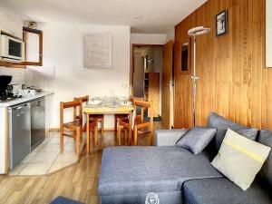 a living room with a couch and a table and a kitchen at Appartement cosy au pied des pistes avec parking et balcon, 4 pers, centre village - FR-1-344-1077 in Saint-Martin-de-Belleville