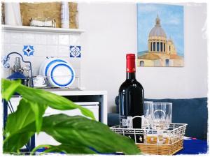 una bottiglia di vino seduta su un tavolo con una pianta di L'arco delle Commari a Ragusa
