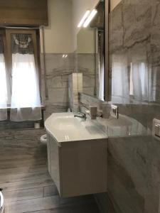 W łazience znajduje się umywalka, toaleta i lustro. w obiekcie A CASA DI LETY w mieście Tarvisio