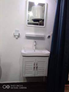 a bathroom with a white sink and a mirror at Le Majestic Toamasina Hotel in Toamasina