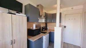 a kitchen with blue cabinets and a counter top at Appartements front de mer Royan in Royan