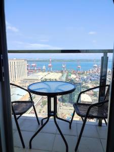a table and chairs on a balcony with a view of the city at Bay View Apartment Sunvida Tower 28 in Cebu City