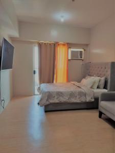 a bedroom with a bed and a couch at Bay View Apartment Sunvida Tower 28 in Cebu City