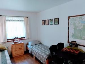ein Schlafzimmer mit einem Bett, einem Schreibtisch und einer Karte in der Unterkunft Uroczysko Ludwinowo na Podlasiu in Łuka