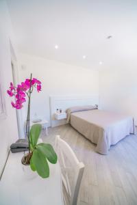 een slaapkamer met een bed en een plant op een tafel bij Minissale Farmhouse in Calatabiano